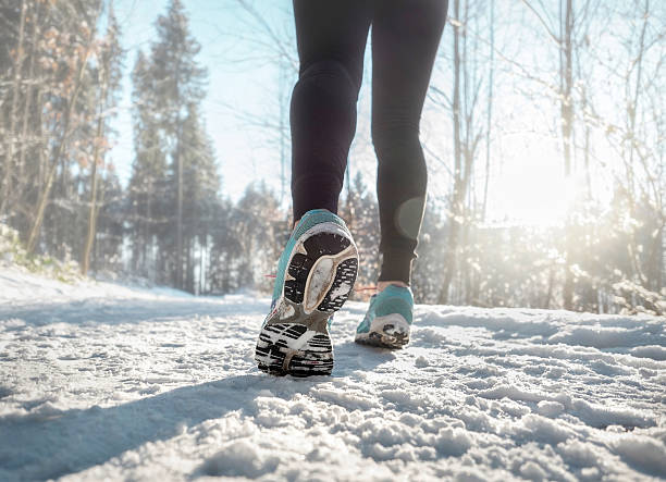 istock Woman Running at snowly winter under sunlight. 542934926