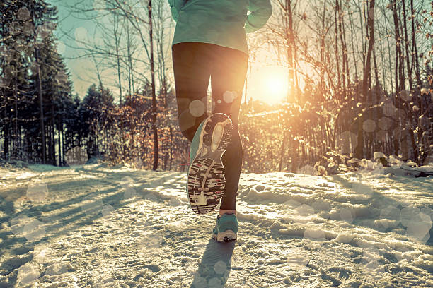 istock Woman Running at snowly winter under sunlight. 542934960