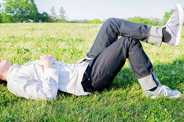 istock Asian man lying lying at green field 542937138