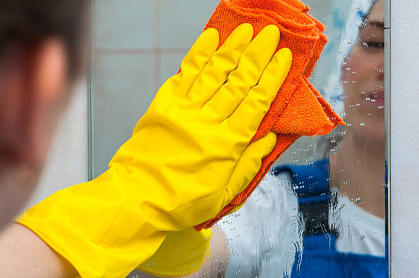 istock Woman cleaning mirror with rag 542938042