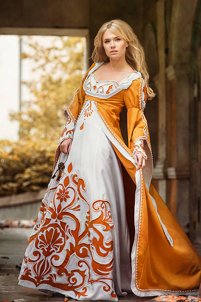 Woman in medieval dress Beautiful blond woman in medieval dress walking near old building renaissance dress stock pictures, royalty-free photos & images