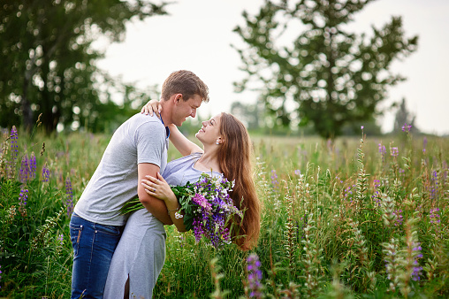 portrait of young stylish fashion couple in field looking on each other.