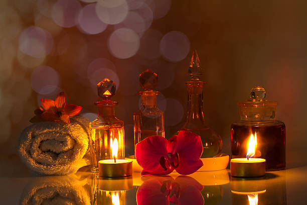 nature morte, huiles aromatiques sur fond bokeh flou - alternative therapy aromatherapy spa treatment candle photos et images de collection