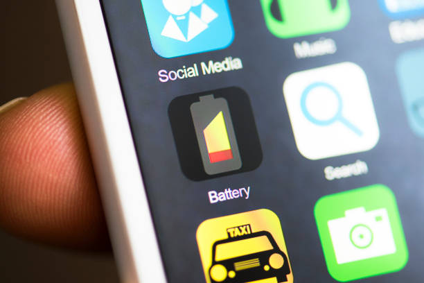 istock Hand holding phone, battery app on screen 542944704