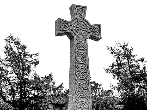 Braemar, United Kingdom - June 6, 2014: This stone Celtic Cross is the public war memorial, located at Braemar, Aberdeenshire, Scotland.  It is located in the public street and commemorates the lives of those lost in the first and second World Wars.  The cross is made of granite from the nearby Inver quarry.  This village is the Royal residence for Her Majesty the Queen during the Autumn months.