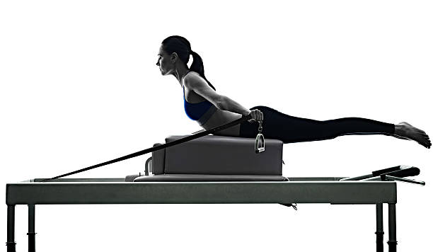 woman ピラティスリフォーマーエクササイズフィットネス絶縁 - pilates machine 写真 ストックフォトと画像