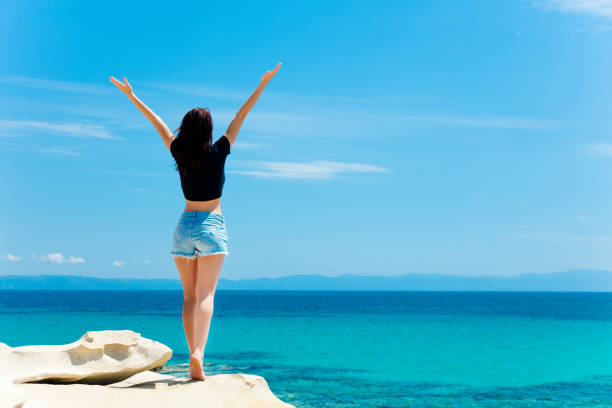 photo of the beautiful young woman on the rock resting in Greece