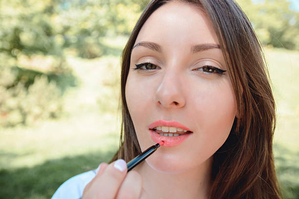 istock Woman rouge lips and looking at telephone as mirror 542949108