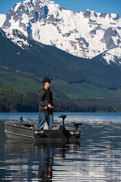 Fly fishing from a boat Fly fishing from a boat on a stunning mountain lake pemberton bc stock pictures, royalty-free photos & images