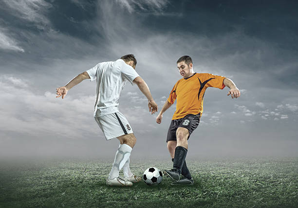 istock Football player with ball in action under sky with clouds 542952188