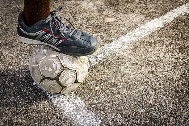 istock Playing old football on concrete field 542956690