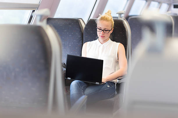istock Woman travelling by train working on laptop. 542956792