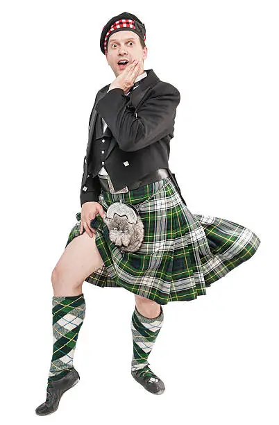 Scottish man in traditional national costume with blowing kilt isolated