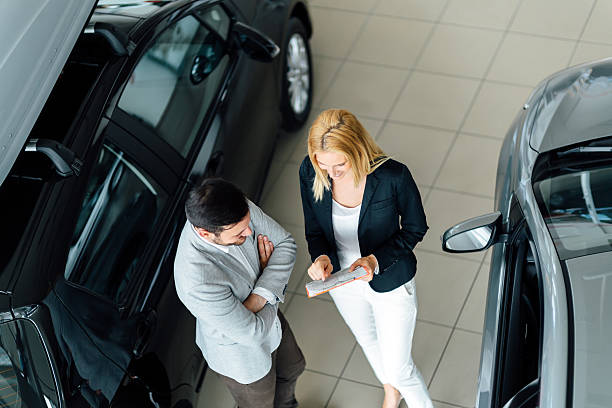 salesperson showing vehicle to potential customer - professional dealer imagens e fotografias de stock