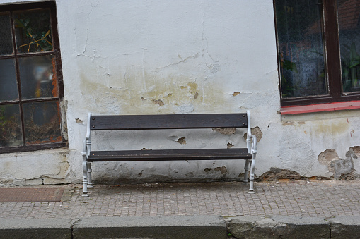 A bench up against an old run down building