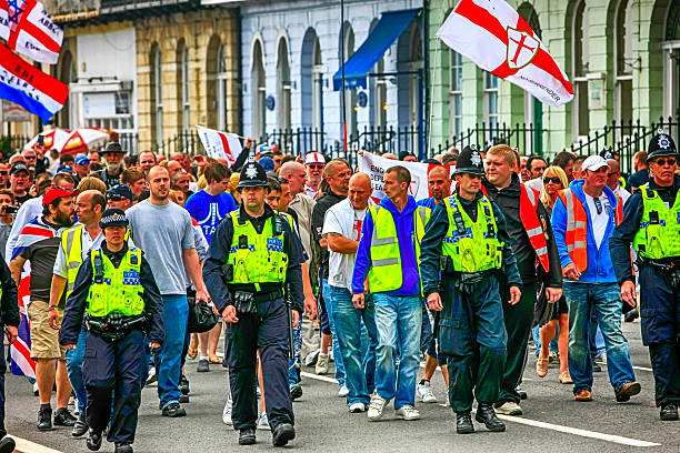 Stones and bricks litter the road as police riot squad move forward