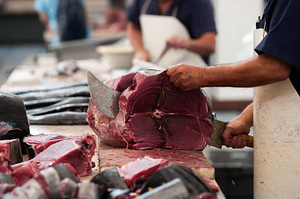 istock Fisherman (salesman) cutting fresh tuna fish in market (restaurant) 542966594
