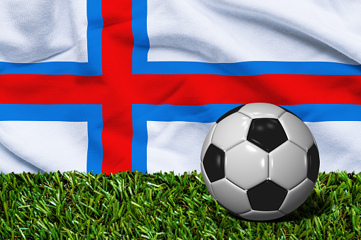 3D rendered soccer ball in grass field with Faroe Islands flag as Background