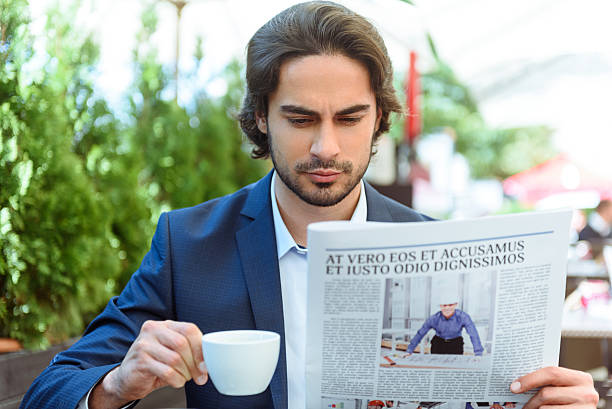 istock Attractive young businessman reading newspaper 542970872