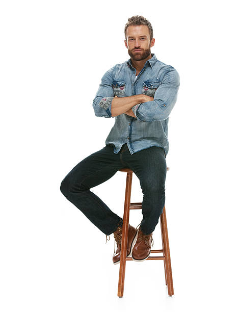 istock Casual man sitting with arms crossed on stool 542970928