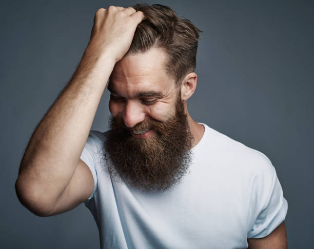 laughing bearded man holding hair and laughing - mirth imagens e fotografias de stock