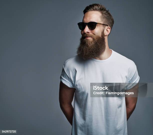 Photo libre de droit de Beau Homme Barbu Avec Des Lunettes De Soleil Regardant Pardessus banque d'images et plus d'images libres de droit de Hommes