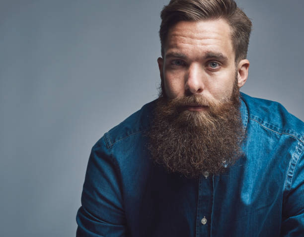 istock Close up on serious man in blue shirt and beard 542973196