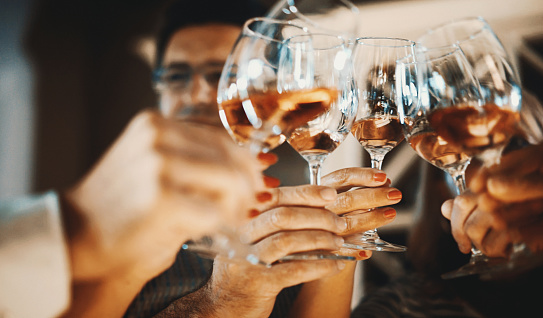 Closeup low angle view of group of unrecognizable people toasting with wine. This toast came after serious winetasting and scrutiny, uploaded soon.