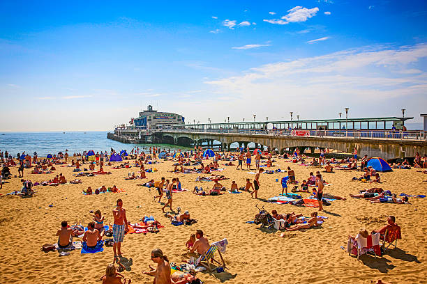 pessoas no cais e praia em bournemouth, reino unido - bournemouth imagens e fotografias de stock