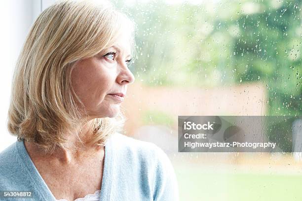 Sad Mature Woman Suffering From Agoraphobia Looking Out Of Windo Stock Photo - Download Image Now