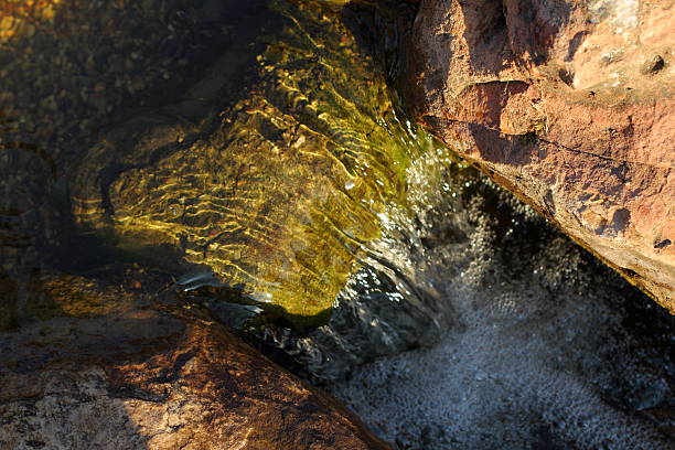steine im bach mit glatt fließendem wasser - natural phenomenon waterfall rock tranquil scene stock-fotos und bilder