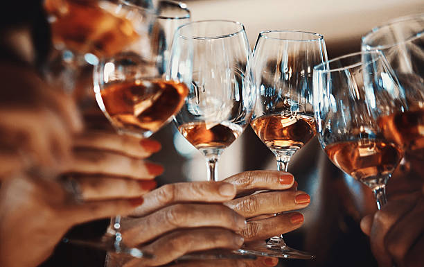 Wine tasting. Closeup low angle view of group of unrecognizable people toasting with wine. This toast came after serious wine tasting and scrutiny, uploaded soon. winetasting rose wine wineglass elegance stock pictures, royalty-free photos & images