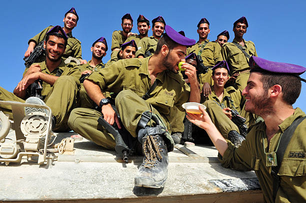 Israeli IDF soldiers Celebrate Rosh Hasahanah Zikim, Israel - September 7, 2010: IDF soldiers are blessing on the traditional jewish custom of apple and honey to welcome Rosh Hasahanah, the Jewish New Year in Gaza border near Zikim, Israel. israeli ethnicity stock pictures, royalty-free photos & images