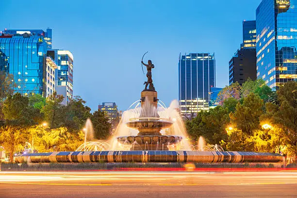 Photo of the landmark Diana the Huntress Fountain (Fuente de la Diana Cazadora) on Paseo de la Reforma avenue in downtown Mexico City, Mexico, at twilight blue hour.