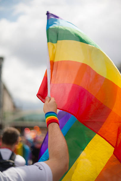 Rainbow gay pride flag and wristband in Pride Parade stock photo