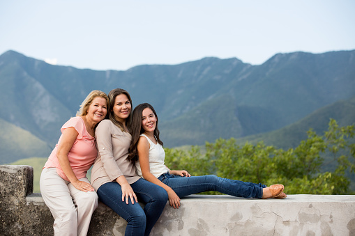 Hispanic ladies smiling whit mountains in the background in thins horizontal shot.