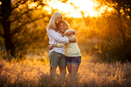 Shot of a mother hugging her adult daughter in the park.