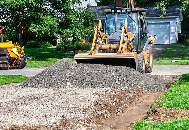 istock Backhoe Front Loader Spreading Gravel For New Driveway Construction 543062528
