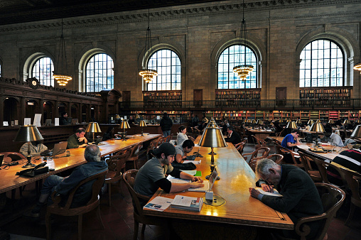 New York, New York, United States - October 14, 2009: People read books at the New York Public Library in Manhattan, New York, USA. At the time it opened in 1911, the Library was the largest marble building ever built in the United States.