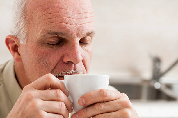 istock Sleepy man holding little coffee cup to his mouth 543063594