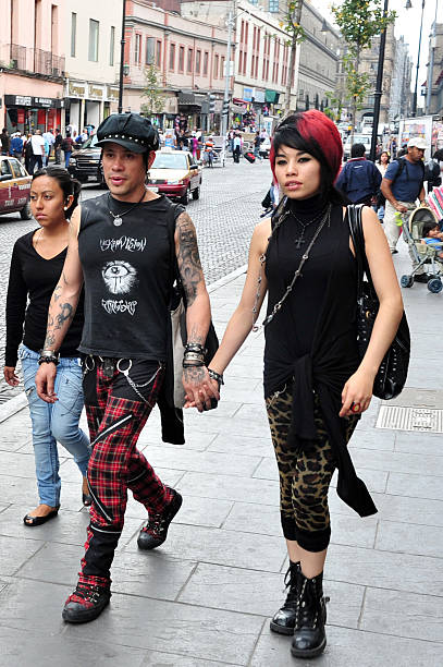 Punk fashion in Mexico City, Mexico Mexico City, Mexico - February 23, 2010: Punk couple hold hands in Mexico City, Mexico. It's a radical style using unconventional combinations of elements and materials with high shock value. emo boy stock pictures, royalty-free photos & images