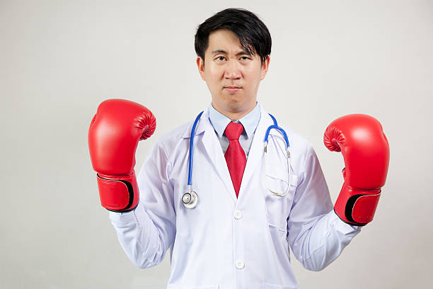 asian doctor wearing boxing gloves in white background - immune defence fotos imagens e fotografias de stock