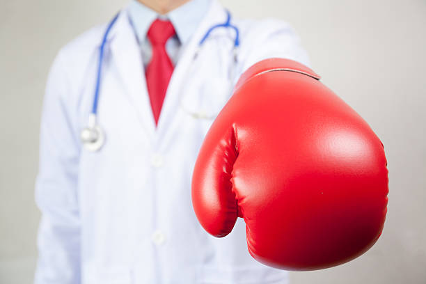 doctor wearing boxing gloves in white background - immune defence fotos imagens e fotografias de stock