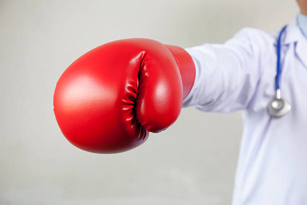 doctor wearing boxing gloves in white background - immune defence fotos imagens e fotografias de stock