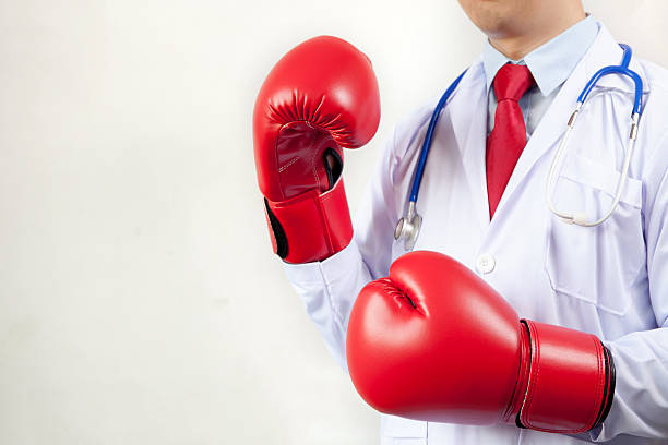 doctor wearing boxing gloves in white background - immune defence fotos imagens e fotografias de stock