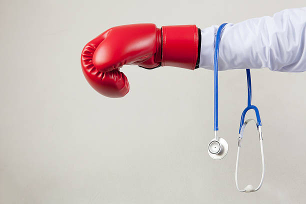 白い背景にボクシンググローブを身に着けている医師 - boxing glove conflict rivalry fighting ストックフォトと画像