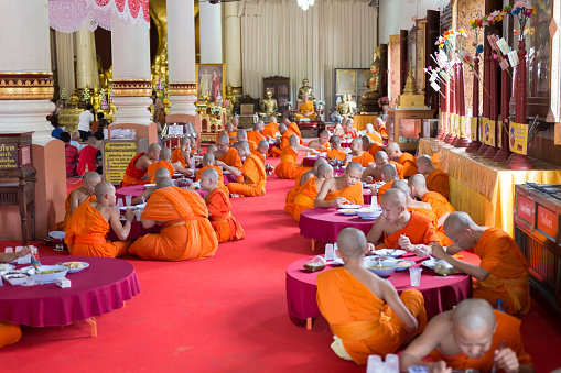 Chiang Mai, Thailand - June 19, 2016:  buddhist monk eat lunch at Phra Sing Waramahavihan temple in Chiang Mai, Thailand on June 19, 2016.