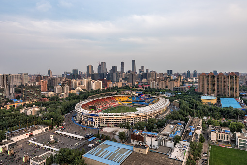 Beijing,China-June 12th,2016：Fans are entering Beijing Workers' Stadium to watch a football game, next to Beijing Workers Stadium is famous for building CBD.