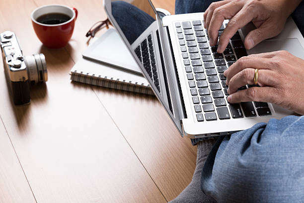 istock man with laptop computer, coffee cup and eyeglasses 543072366