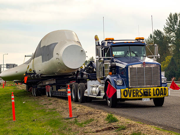 Truck with Oversize Load Sign Carring B-1 Bomber I-5 Oregon Jefferson, Oregon, USA - November 9, 2011: The front of a truck with an " Oversize Load " sign on its front bumper. It is hauling a B-1 Bomber from Arizona  to The Boeing Co. in Renton, Washington for testing. The Oregon Department of Transportation has said it is among the largest loads to be hauled through the state at 35 feet long, 29 feet wide and 15 feet high. It only travels at night due to a speed of 45 MPH or slower and using 2 freeway lanes. This vehicle is parked along the side of the freeway ( Interstate 5 ) at Santiam River Rest Area 8 miles north of Albany, OR near the town of Jefferson, OR. b1 bomber stock pictures, royalty-free photos & images